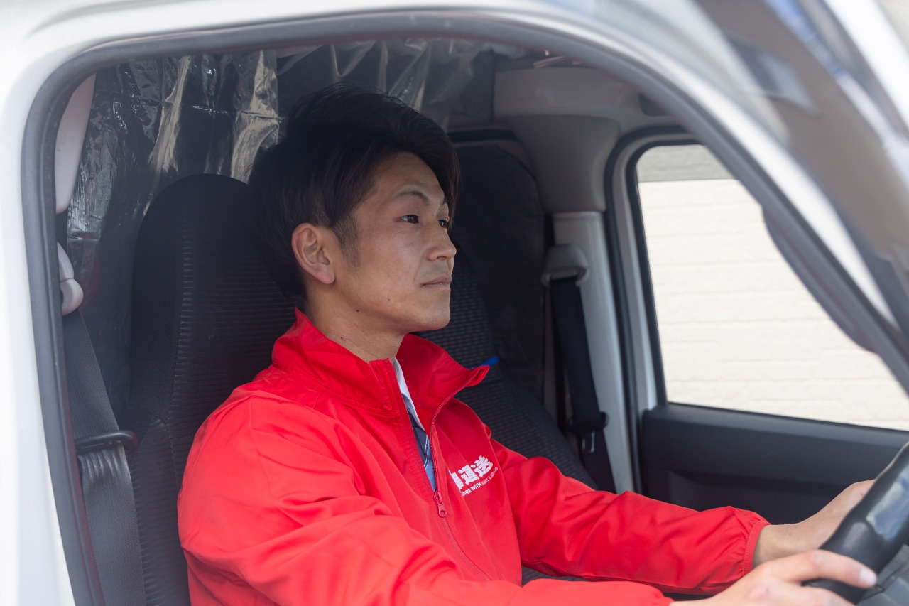 車を運転する配送員